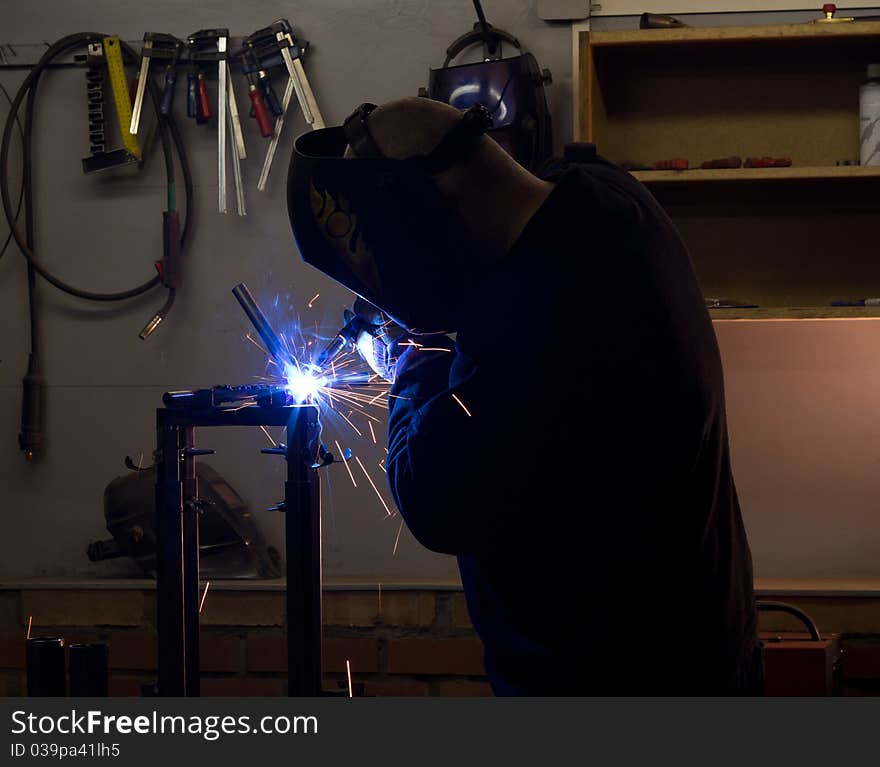 Welder in workshop welding metalic details