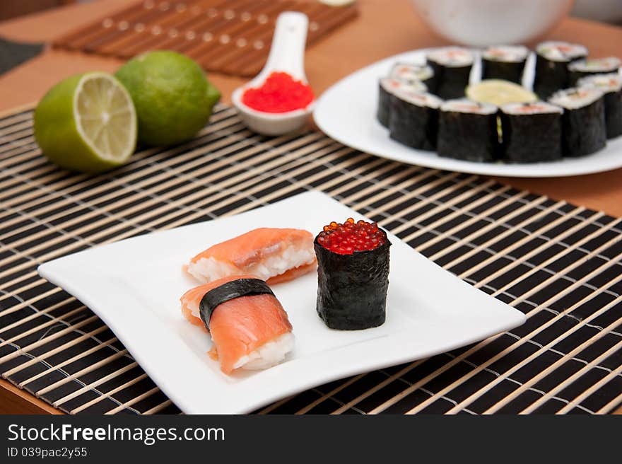 Sushi and gunkan on the plate on bamboo mat