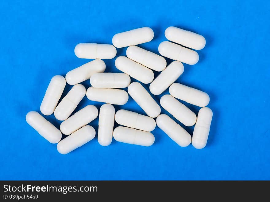 Macro view of white pills on a blue background