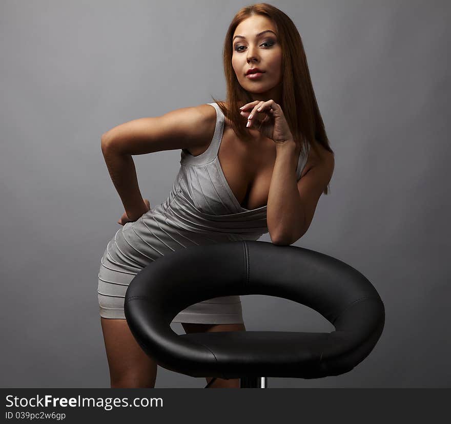 Beautiful girl pose near stylish armchair. Photo.