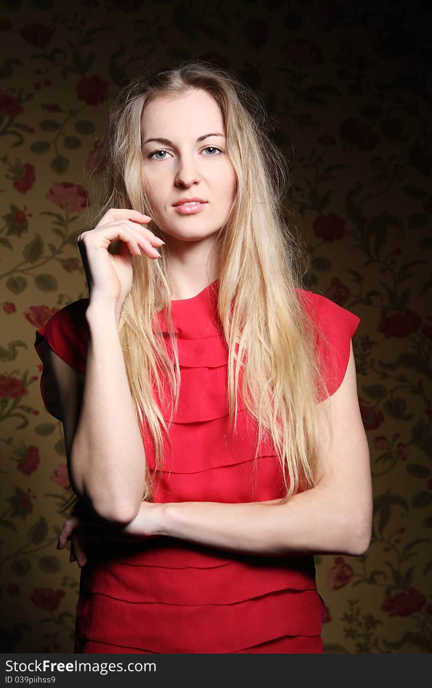 Portrait of the beauty young blond girl near the wall with roses