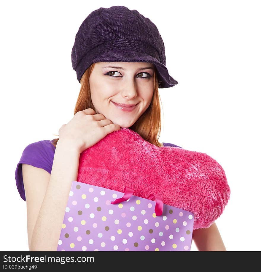 Beautiful red-haired girl with heart in bag. Studio shot.