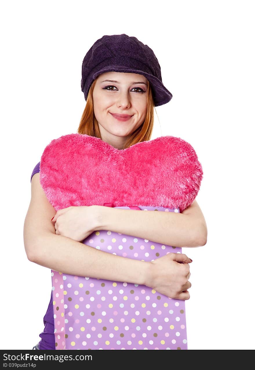 Beautiful red-haired girl with heart in bag. Studio shot.