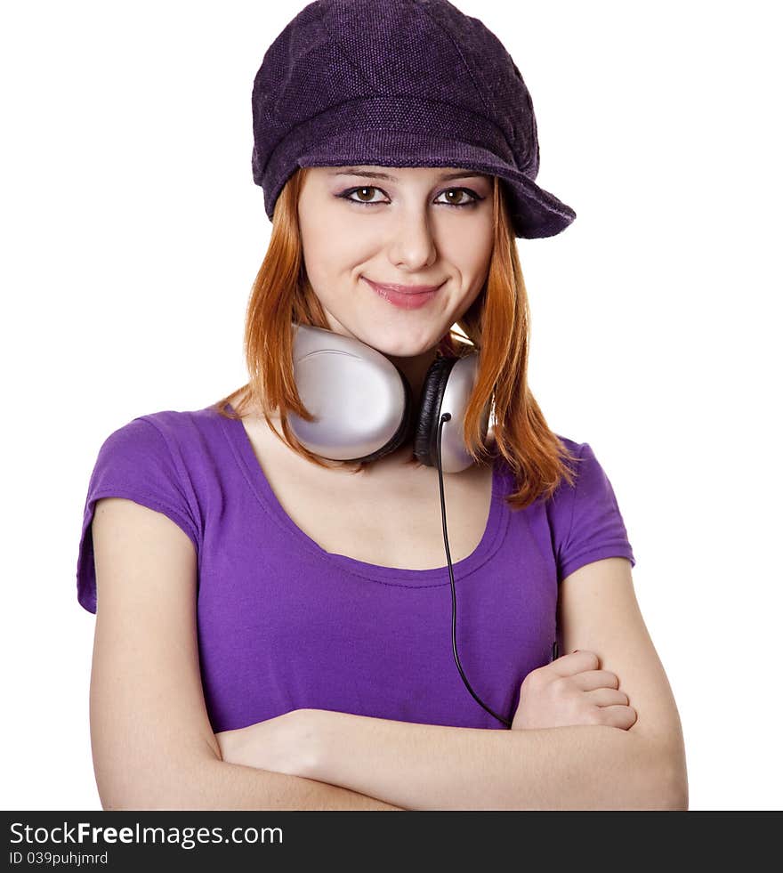 Beautiful red-haired girl with headphones. Studio shot.