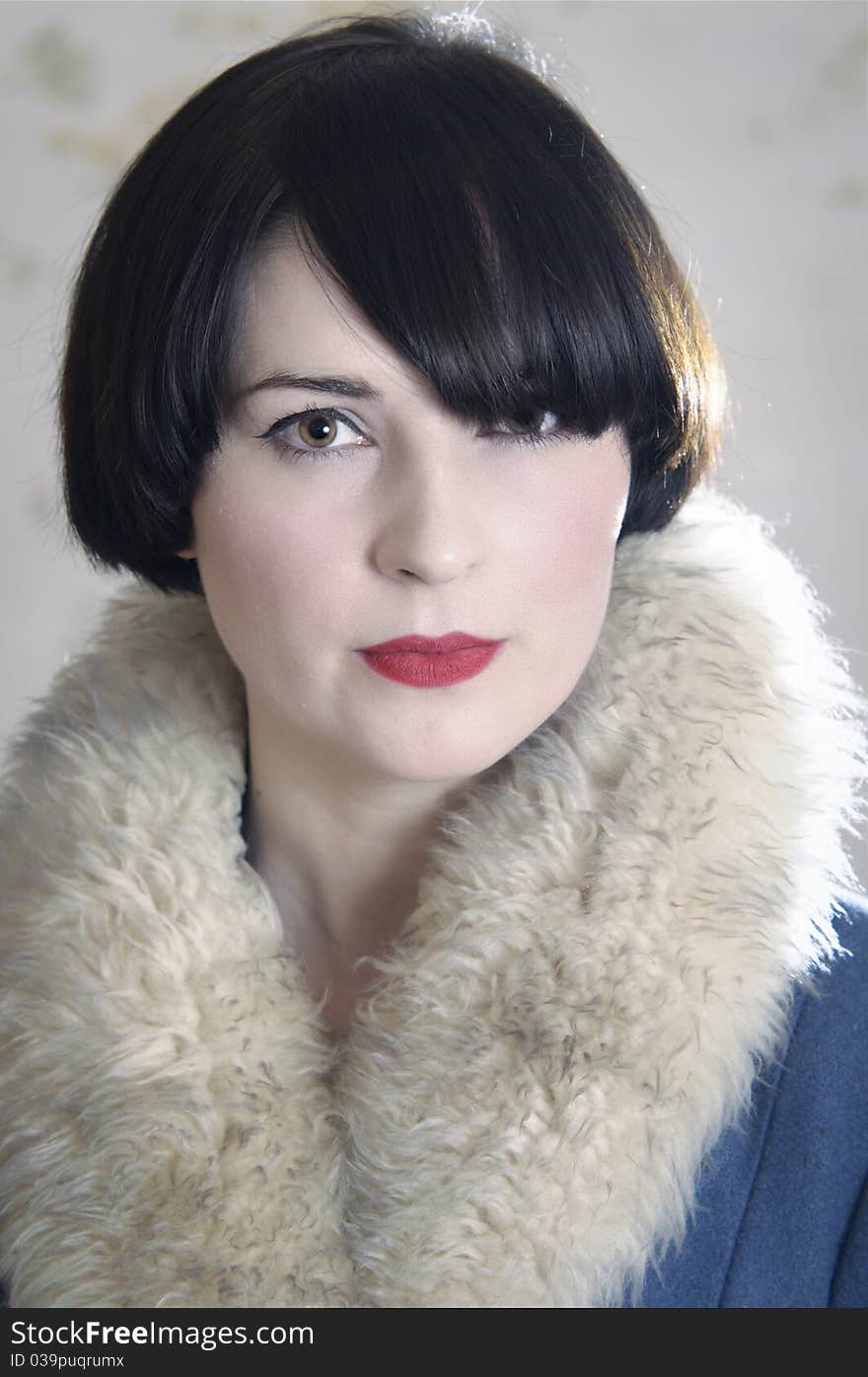 Close up of photo of a beautiful dark-haired young woman wearing a coat with a fake fur collar. Close up of photo of a beautiful dark-haired young woman wearing a coat with a fake fur collar.