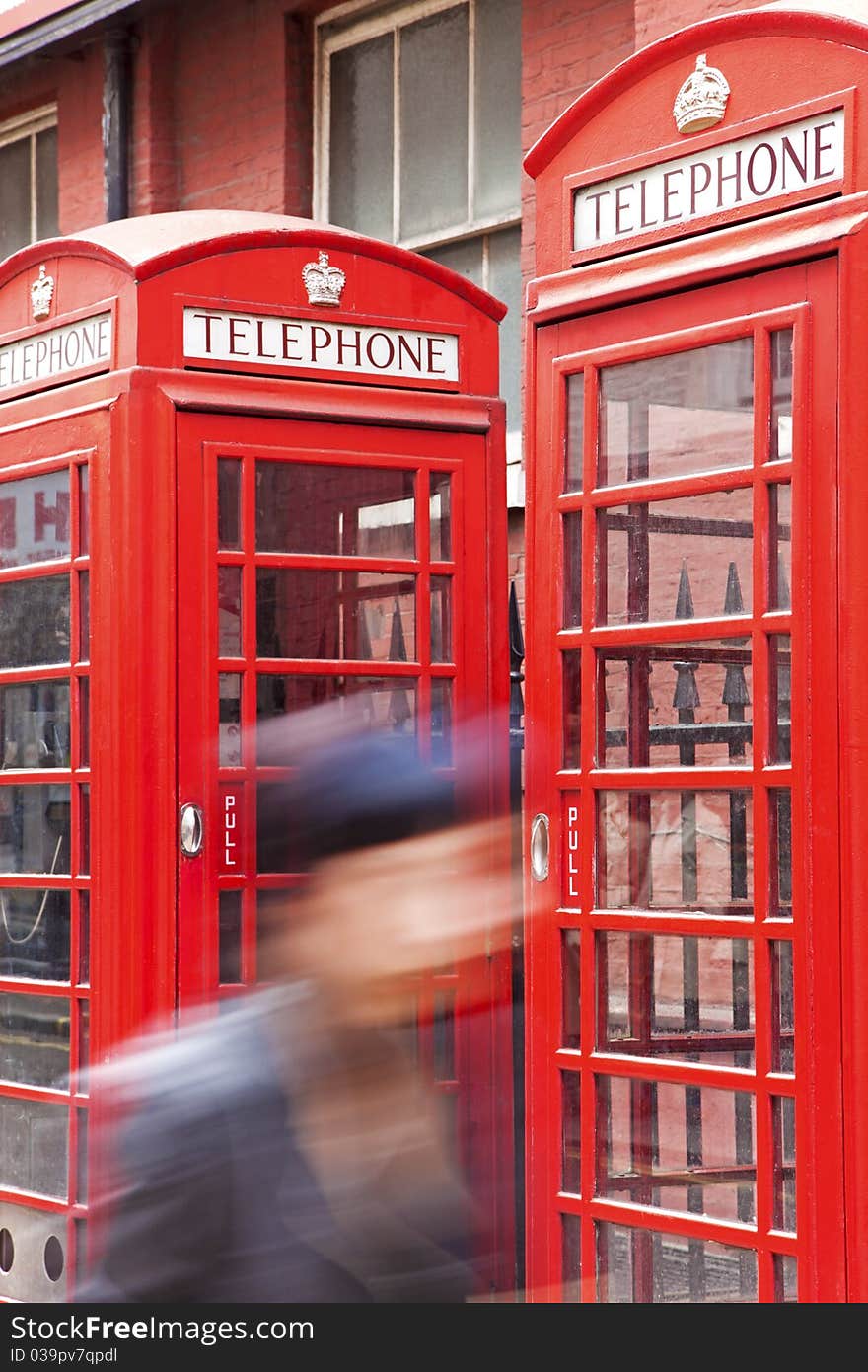 Passing in the foreground, the background red phone boxes in London. Passing in the foreground, the background red phone boxes in London