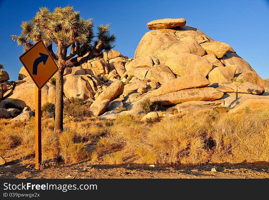 Road arrow sign pointing to rock