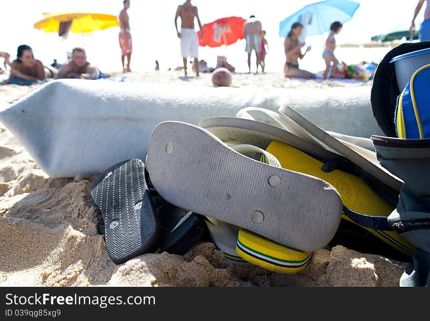 A pile of flip flops on the beach