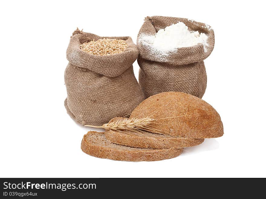 Flour and wheat grain with bread on white