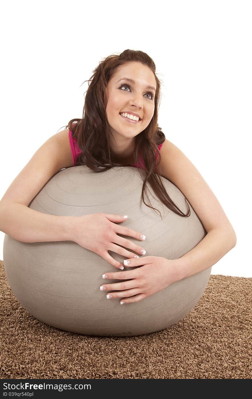 A woman is leaning on a large fitness ball. A woman is leaning on a large fitness ball