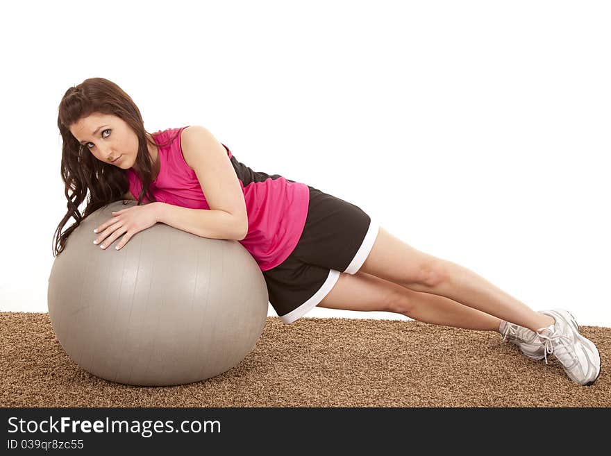 A woman is laying on her side on a big ball. A woman is laying on her side on a big ball.