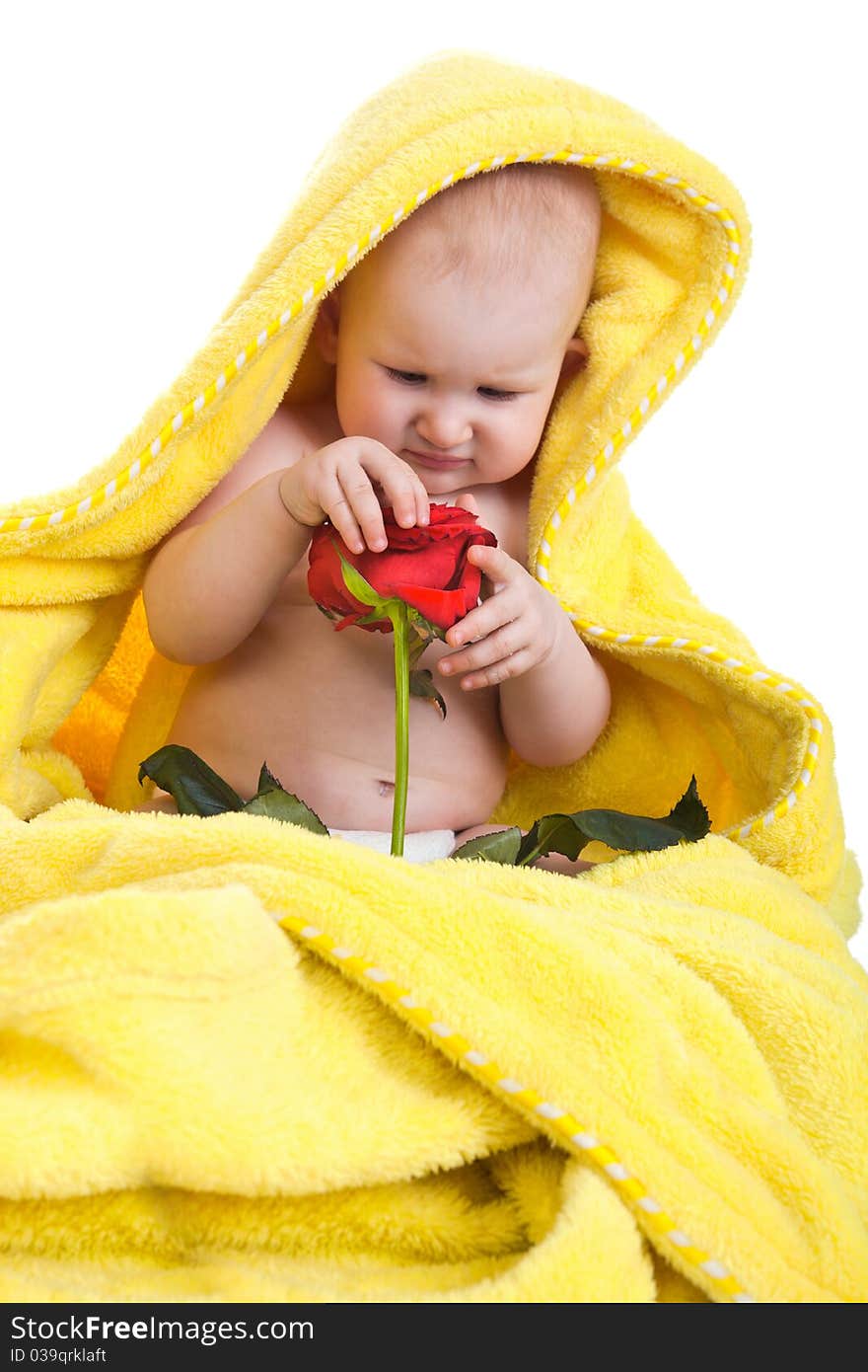 The child with a red rose sits on a floor in a yellow dressing gown. The child with a red rose sits on a floor in a yellow dressing gown