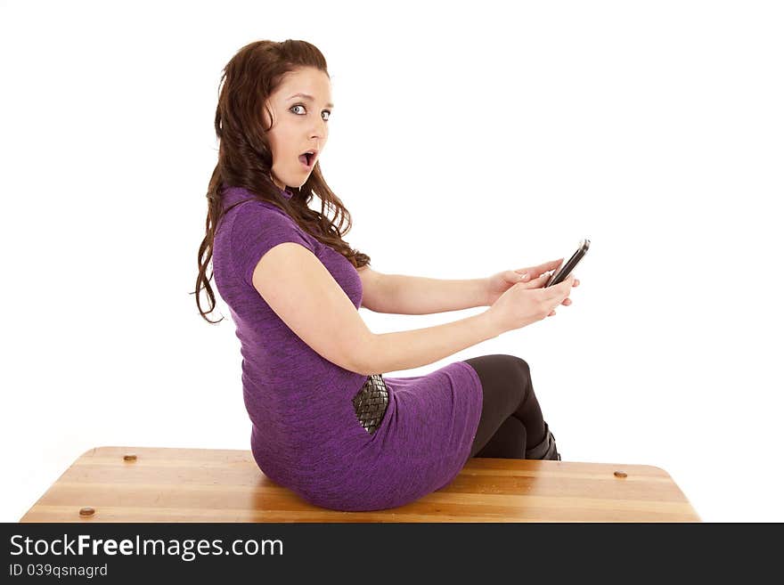 A woman in purple is shocked at her phone. A woman in purple is shocked at her phone.