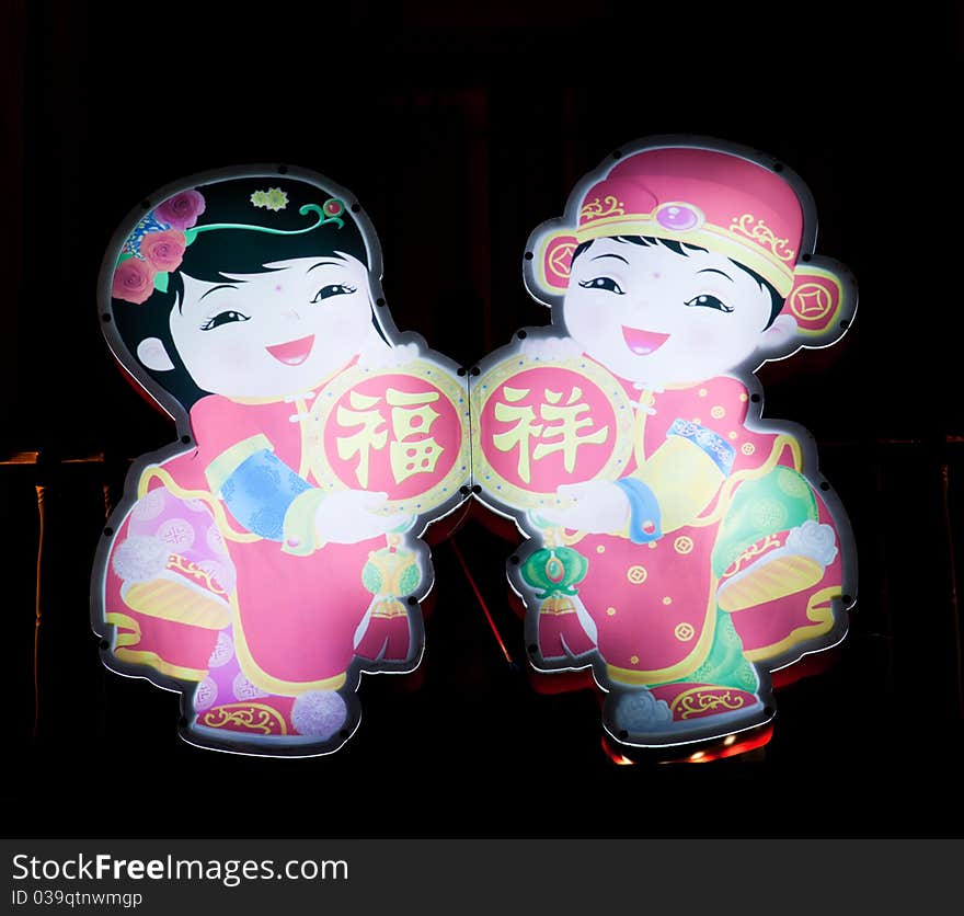 Chinese decorative children lantern agsinst dark background.