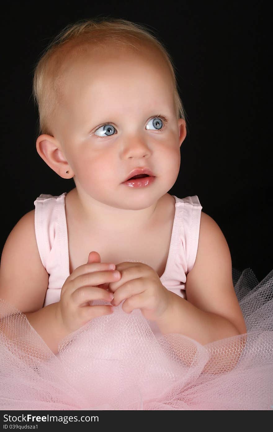 Cute blond baby ballerina looking into the distance