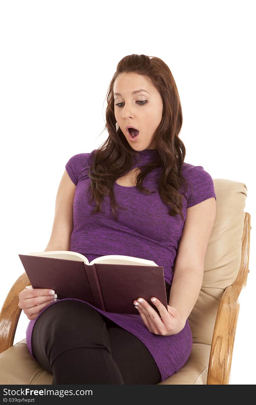 A woman in purple is shocked while reading a book. A woman in purple is shocked while reading a book.