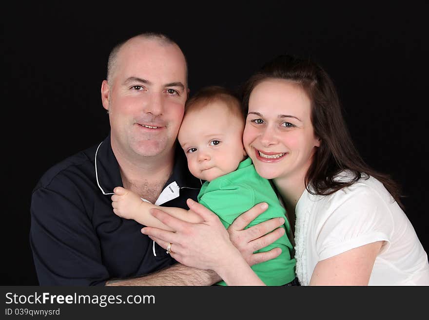 Family of three against a black background