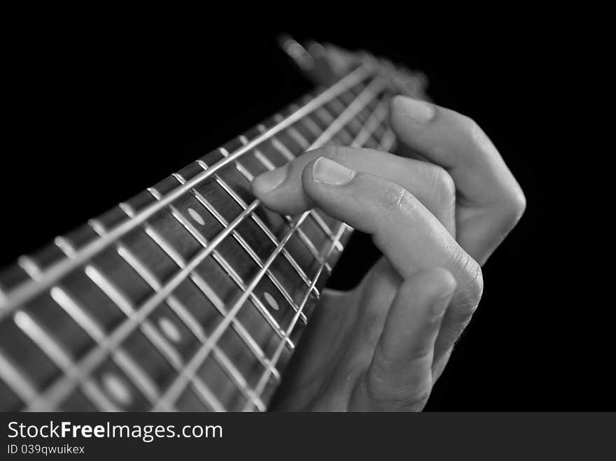 Fingers on electrical bass guitar fretboard, black and white. Fingers on electrical bass guitar fretboard, black and white