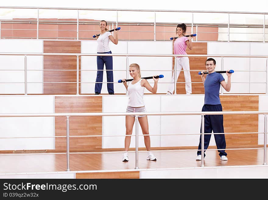 Attractive young people doing exercises in the fitness club. Attractive young people doing exercises in the fitness club