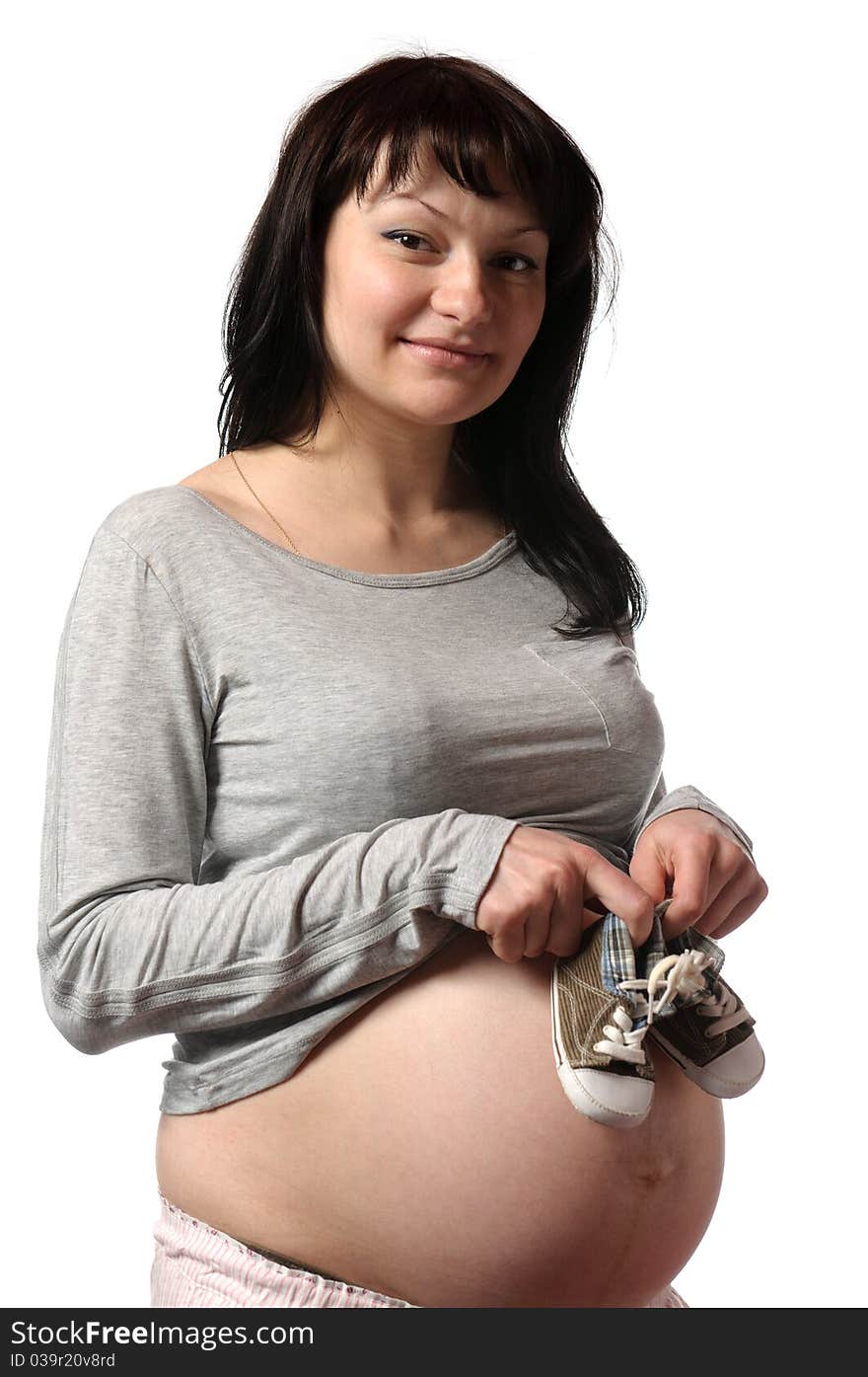 Pregnant young woman with small shoes