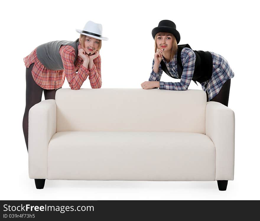 Two girls on the couch with a mustache painted on a white background