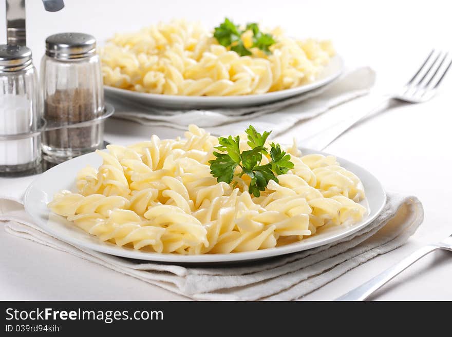 Two plates of pasta with parsley