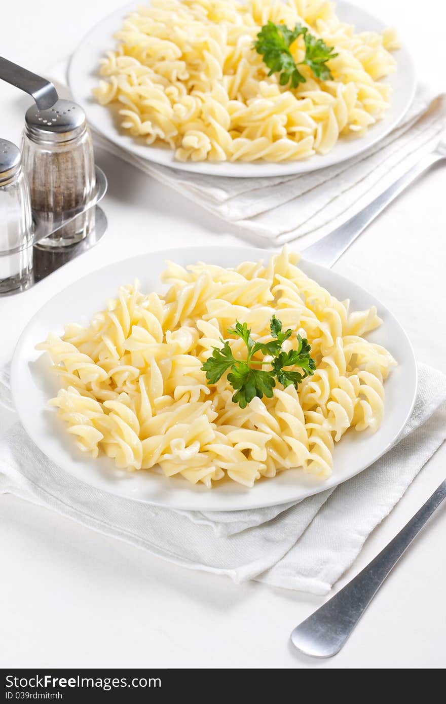 Two plates of pasta with parsley