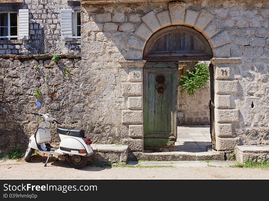 White moped next to broken old wooden gates. White moped next to broken old wooden gates