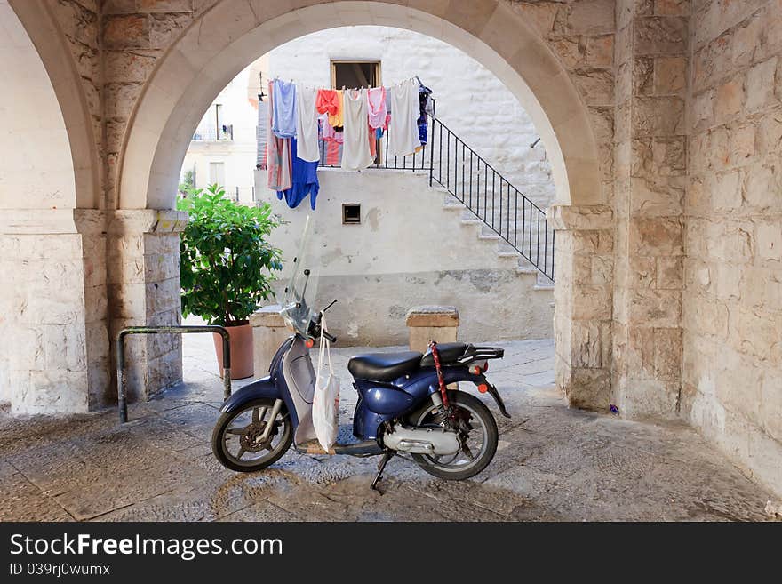 Retro blue moped under an arch in Italy. Retro blue moped under an arch in Italy