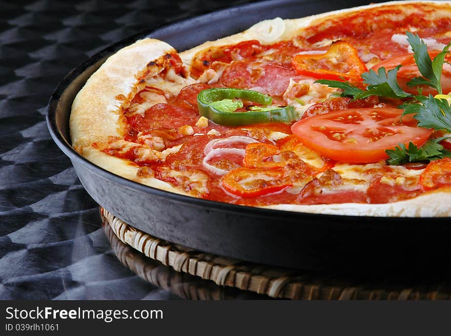 Appetizing italian pizza with tomatoes, persley, onion on steel background. Appetizing italian pizza with tomatoes, persley, onion on steel background