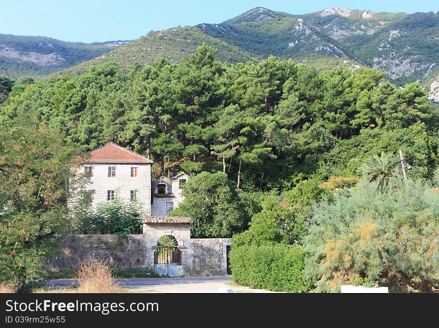 Traditional stone house in trees at the foot of a mountain. Traditional stone house in trees at the foot of a mountain