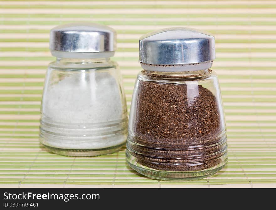 Salt and pepper shaker on a green background