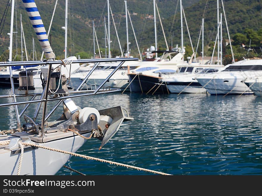 Sailboat bow and anchor with luxury power yachts