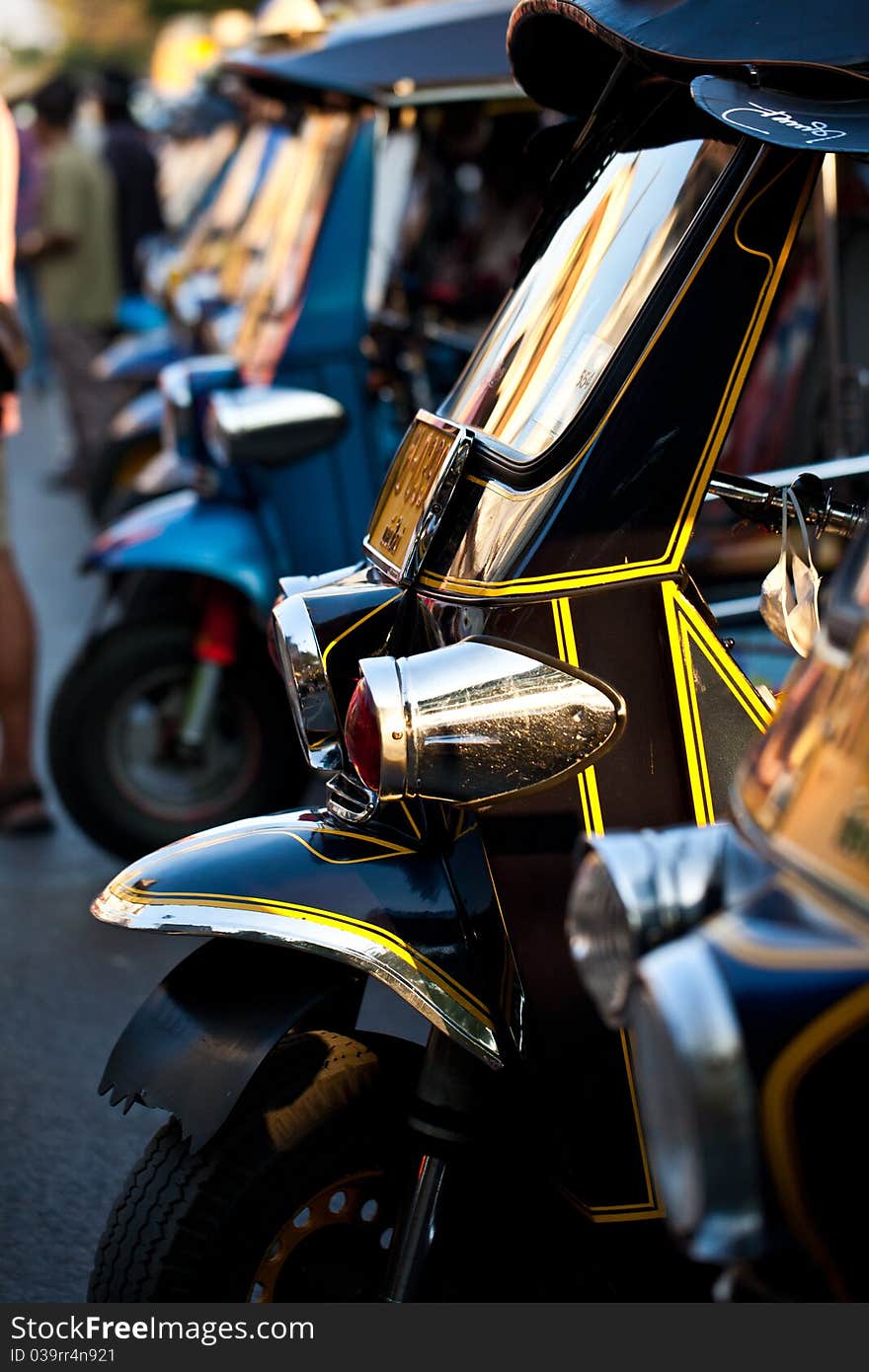 Detail of old tuk tuk taxis with cracked paint in Bangkok. Shallow depth of field with parts of the nearest taxi in focus. Detail of old tuk tuk taxis with cracked paint in Bangkok. Shallow depth of field with parts of the nearest taxi in focus.