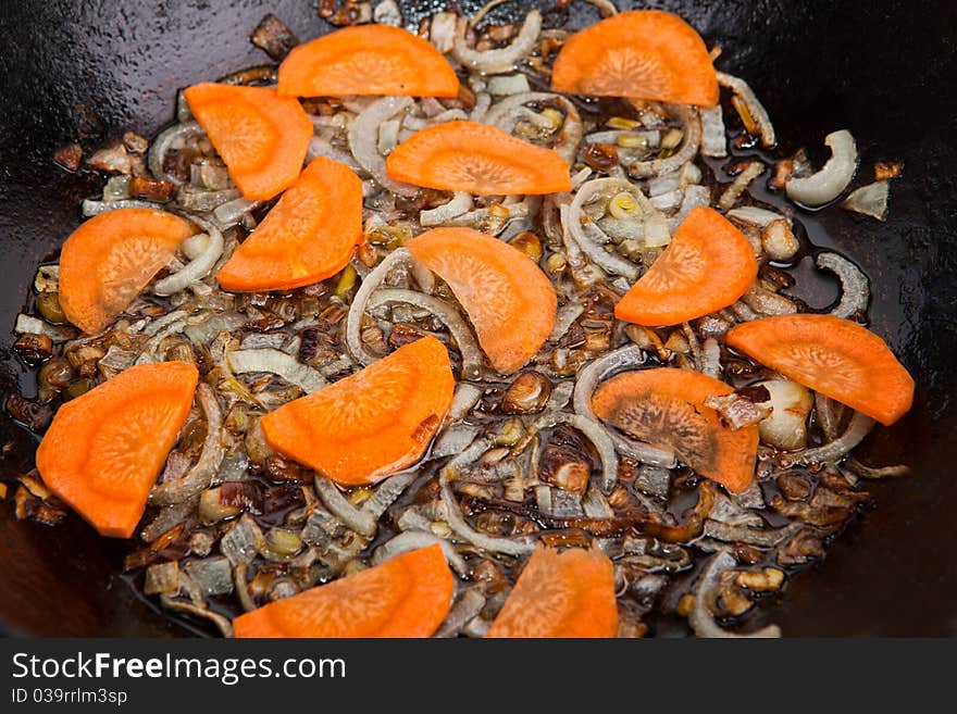 Carrot and onion are being boiled in pan