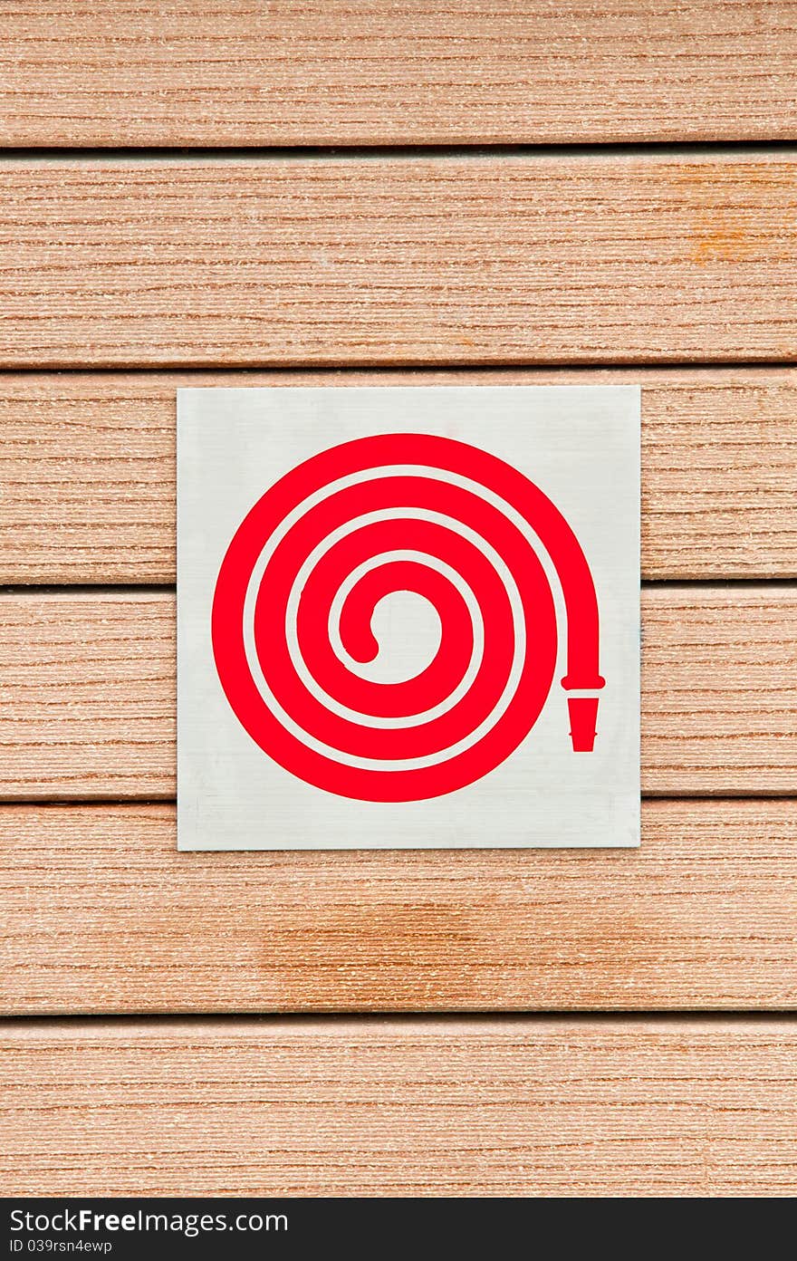 Fire hose symbol on a wooden background