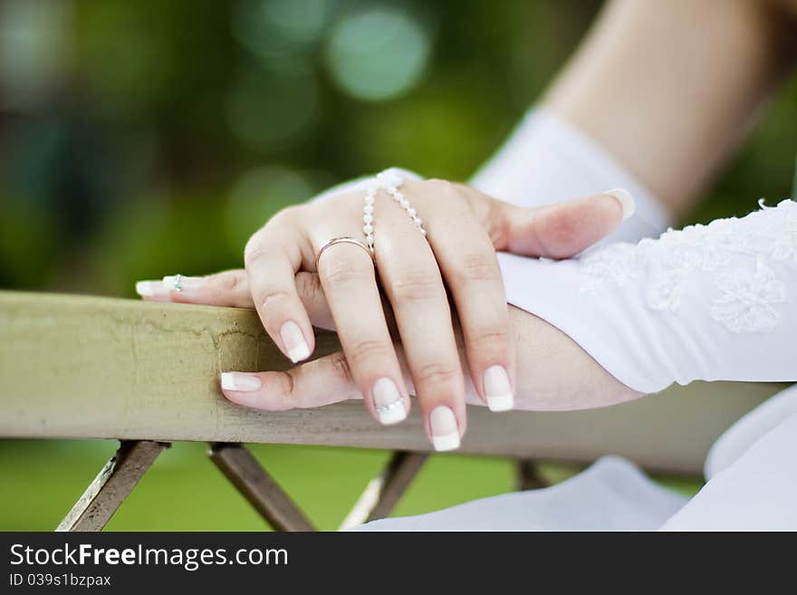 Palms of the bride are beautifully crossed and the wedding ring is visible