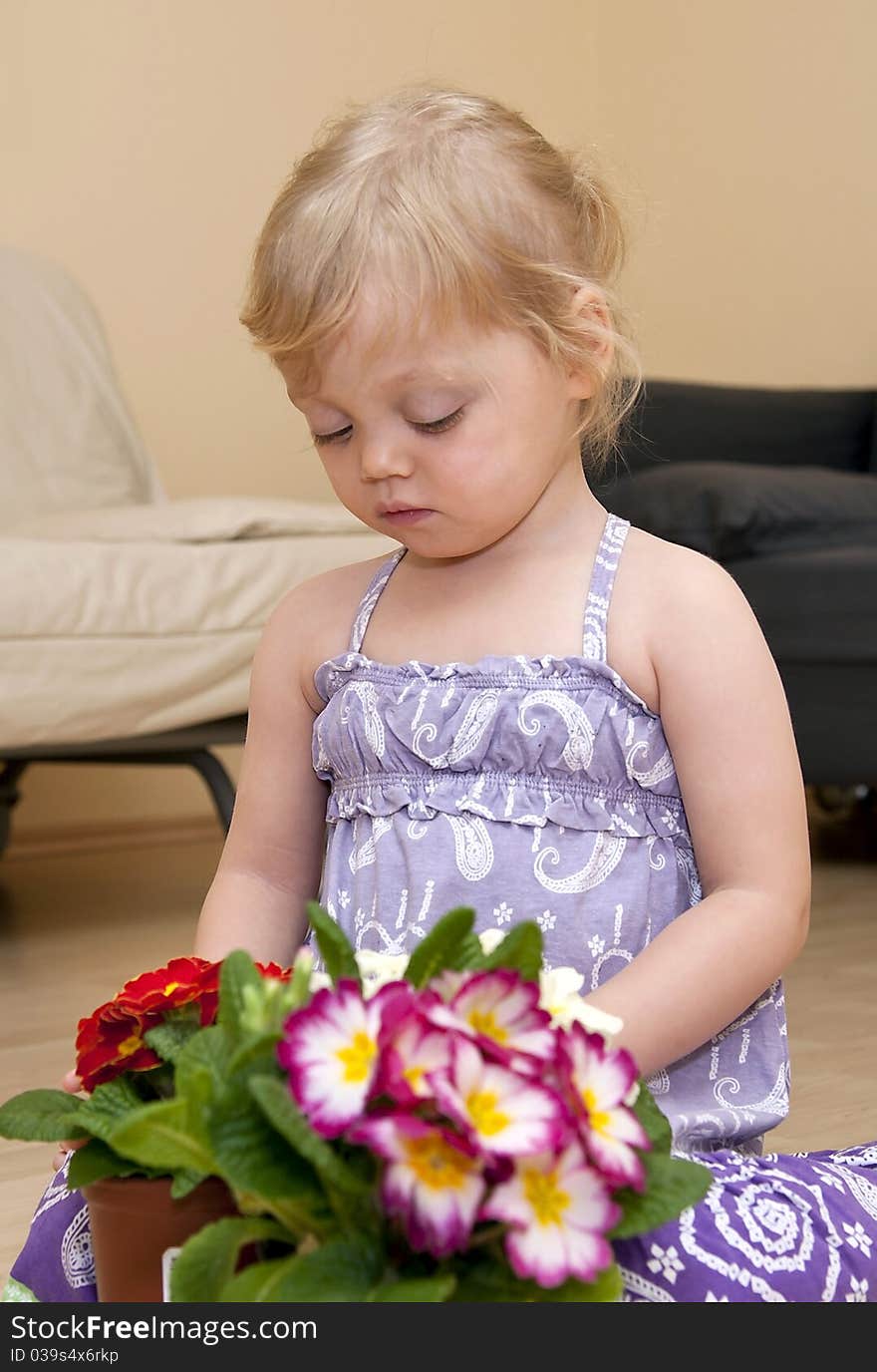 Girl Sits On The Floor And Plays With Flower