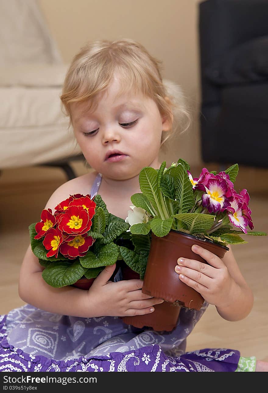 Girl sits on the floor and plays with flower