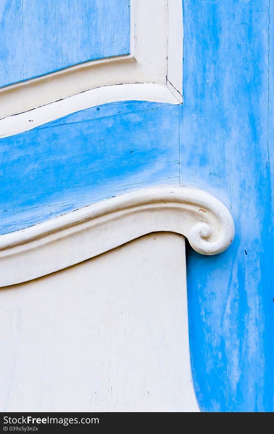 Part of the old wood door painted in blue and white colors. Part of the old wood door painted in blue and white colors