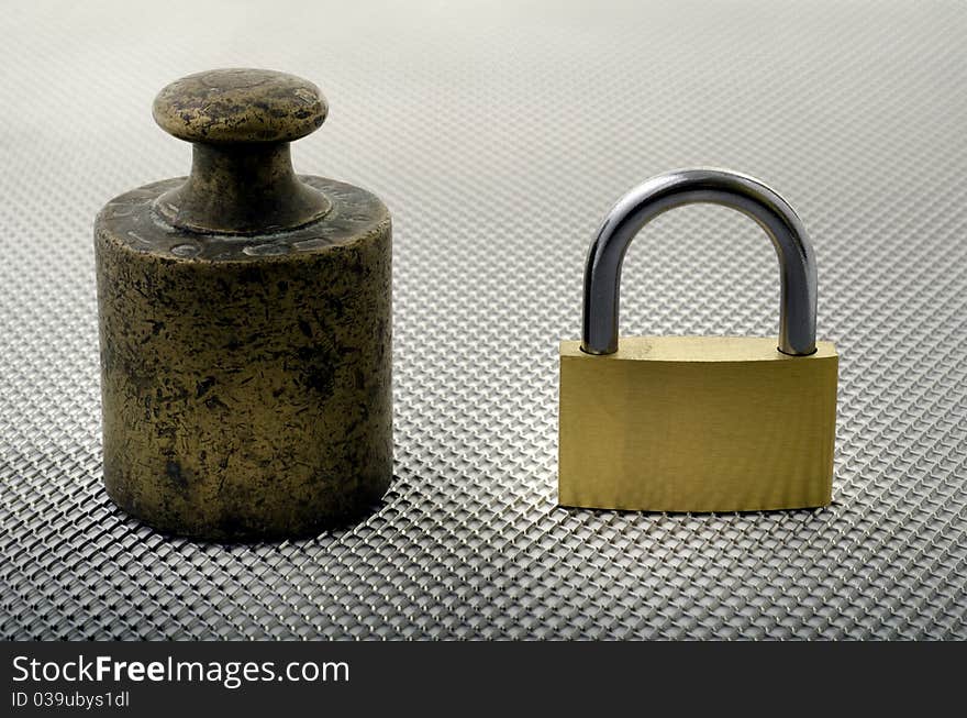 An old weight of bronze and a padlock. An old weight of bronze and a padlock