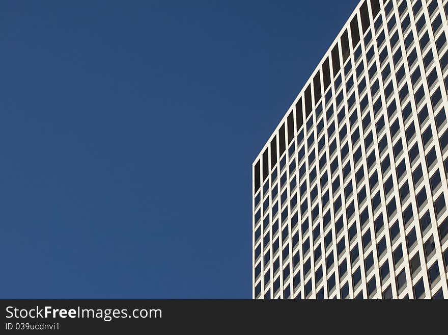 Looking up at a detail of a modern concrete and glass office building