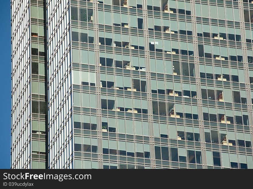 Looking up at a detail of a modern steel and glass office building. Window shades and furniture create an interesting pattern. Looking up at a detail of a modern steel and glass office building. Window shades and furniture create an interesting pattern.