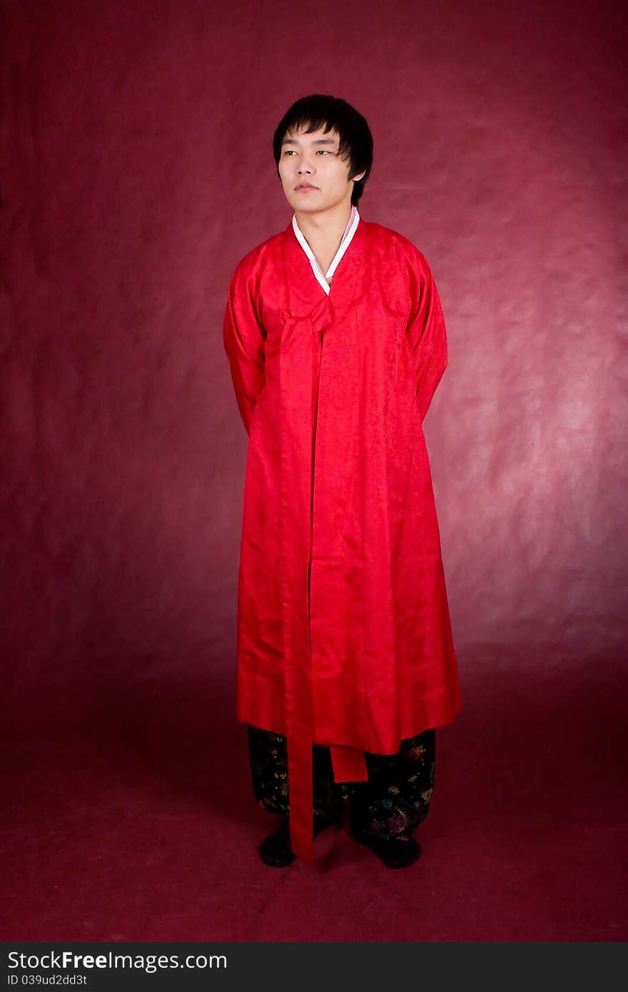 Korean man in a traditional dress on the red background.