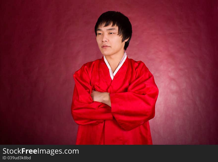 Korean man in a traditional dress on the red background.