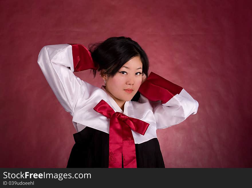 Elegant chinese model in traditional dress on the red background.