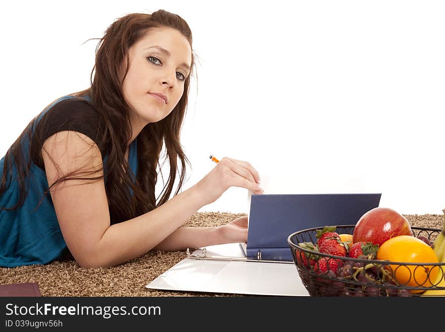 A woman is laying by a book and reading and writing. A woman is laying by a book and reading and writing.