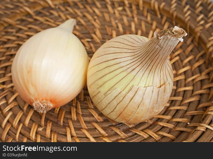 Ripe onions on a wicker plate