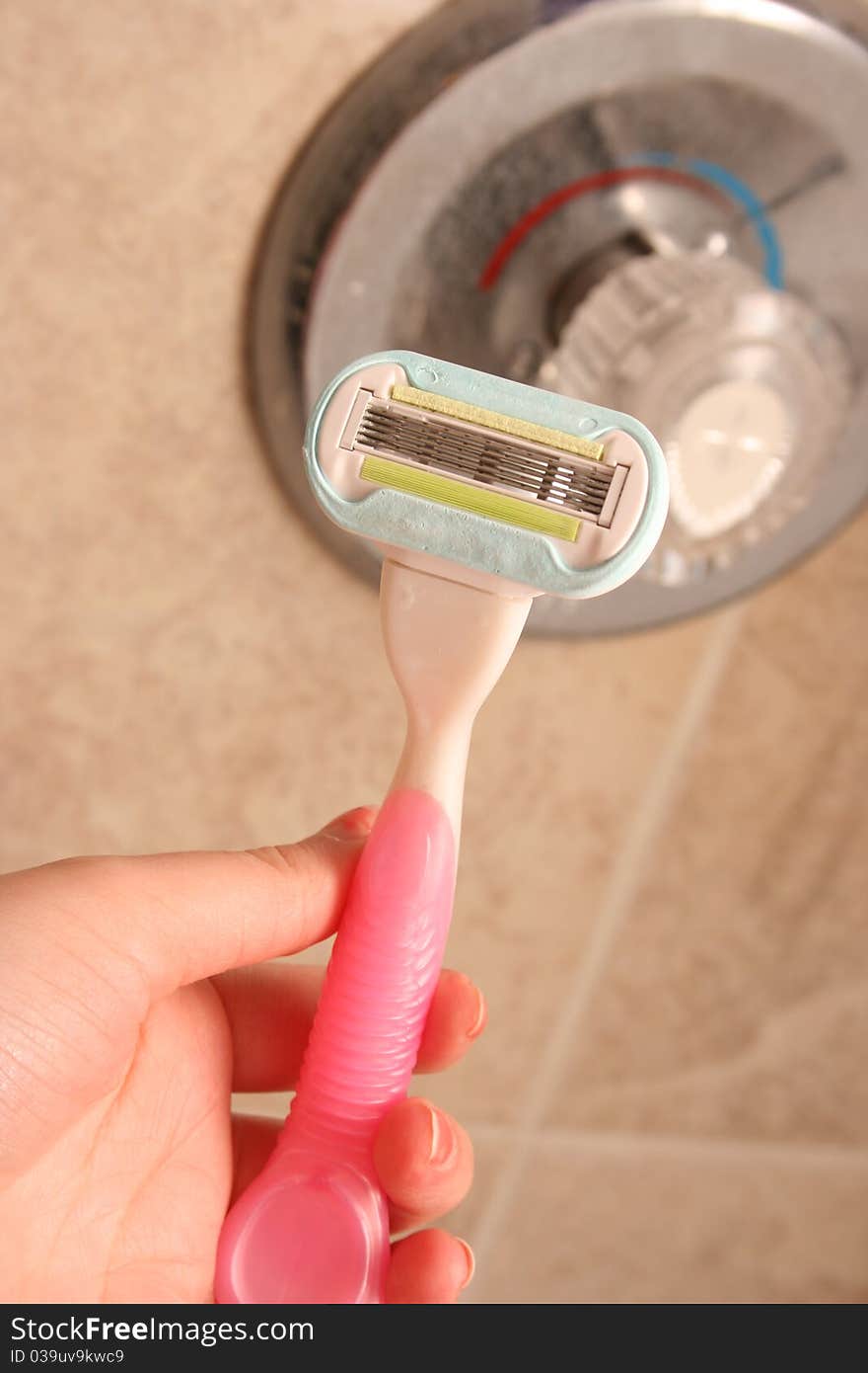 Lady's pink shaver in the shower.