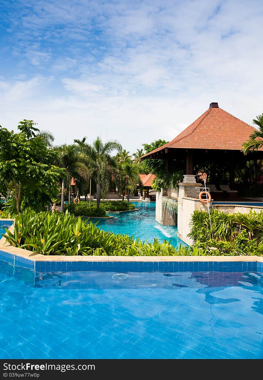 Swimming pool in tropical garden with flowers and trees at the poolside. Swimming pool in tropical garden with flowers and trees at the poolside